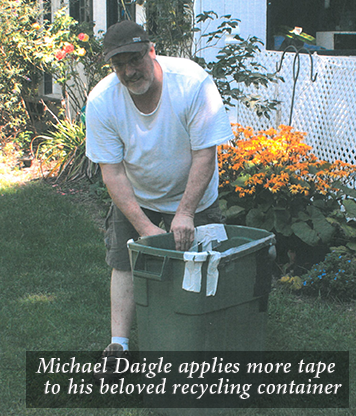 Michael Daigle applies more tape to his beloved recycling container