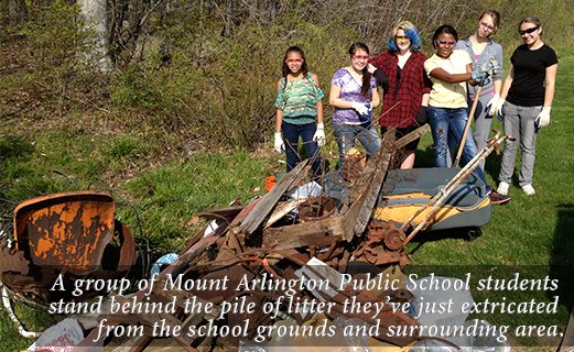 A group of Mount Arlington Public School students stand behind the pile of litter they've just extricated from the school grounds and surrounding area.