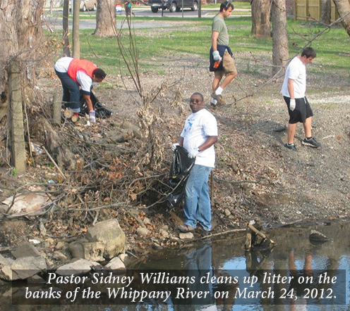 Pastor Sidney Williams cleans up litter on the banks of the Whippany River on March 24, 2012.