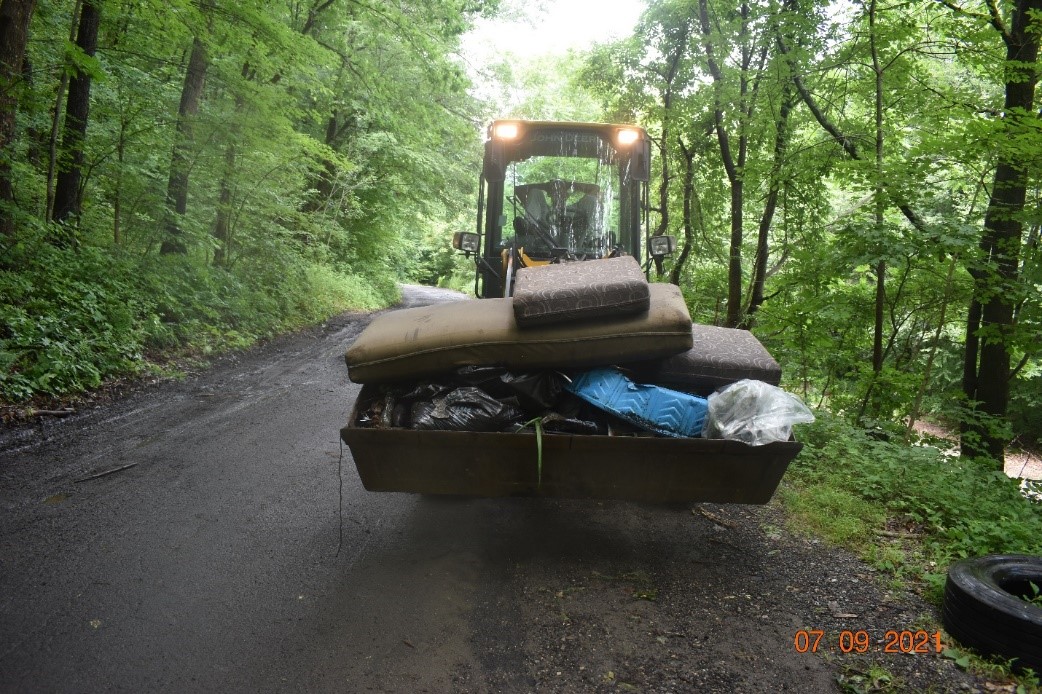 image of pulling garbage bag from woods